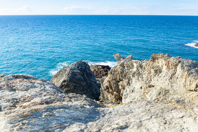 Rock formations by sea against sky