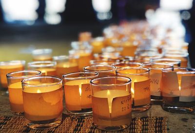 Close-up of illuminated tealights on table