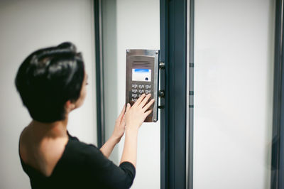 Close-up of young woman using digital door lock