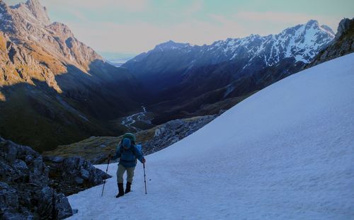 Rear view of man standing on snow covered mountain