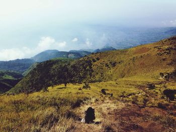 Scenic view of mountains against cloudy sky