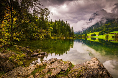 Scenic view of lake by trees against sky