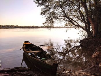 Boat moored on lake against sky