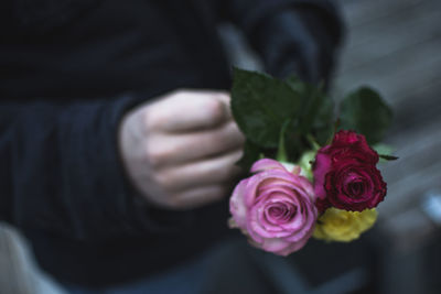 Close-up of hand holding rose bouquet