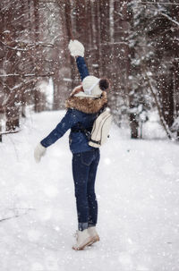 Full length of young woman standing on snow