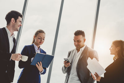 Business people discussing while standing in office