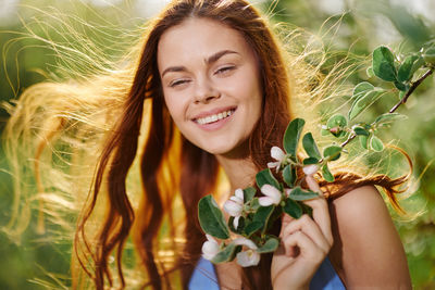 Portrait of young woman sitting on field