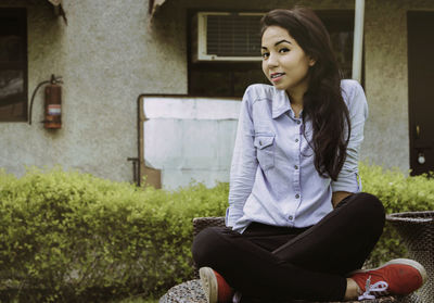 Portrait of young woman standing on grass