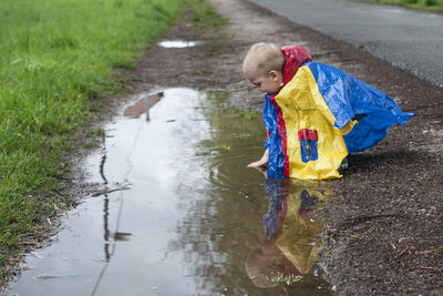 Rear view of woman walking on puddle