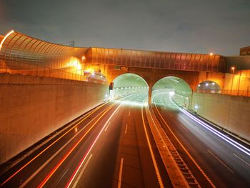 Light trails on bridge in city at night