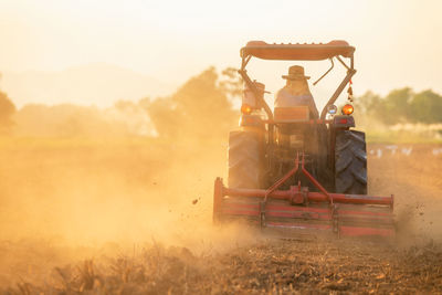 Man working on agricultural field during sunset