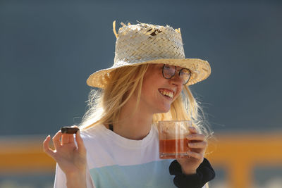 Portrait of a smiling young woman drinking glass