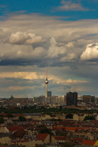 Buildings in city against cloudy sky