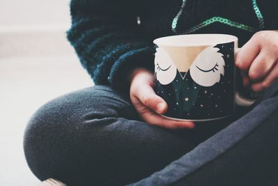 Midsection of child holding coffee cup