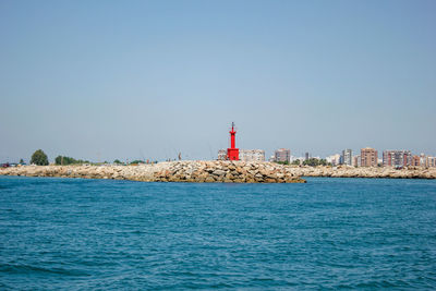 Red lighthouse at the entrance and exit of the cullera boat marina, valencia, alicante, spain. 