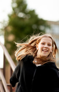 A teenage girl has fun and slides down the railing at the stadium