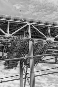 Low angle view of crane at construction site against sky