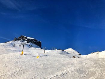 Scenic view of snowcapped mountains against blue sky