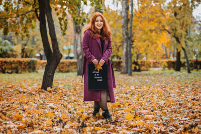 Hello autumn. red hair girl with letter message board with text autumn is my favorite color