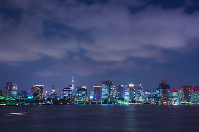 Illuminated buildings in city against sky at night