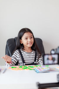 Smiling girl blogging at home