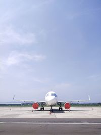 Airplane on runway against sky