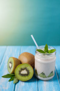 Kiwi fruits and smoothie jar on table