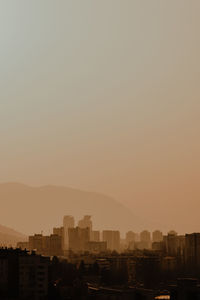 Silhouette buildings against sky during sunset