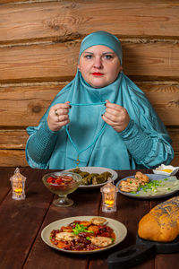 Portrait of woman having food on table