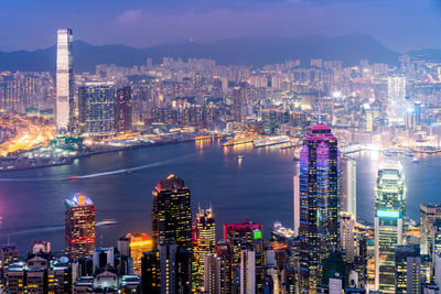 Illuminated modern buildings in city against sky