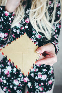 Midsection of woman holding envelopes
