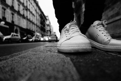 Low section of person wearing shoes on street