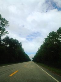 Road amidst trees against sky