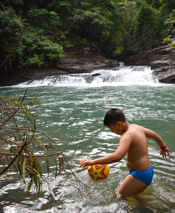Rear view of man swimming in lake