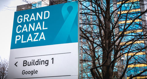 Low angle view of information sign against blue sky