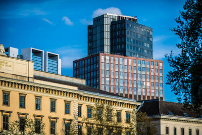 Low angle view of old and modern buildings against sky