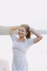 Portrait of young woman standing against wall