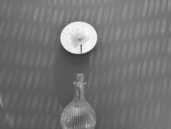 Close-up of glass bottle on table against wall