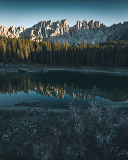 Scenic view of lake by mountain against sky