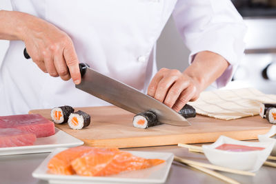 Midsection of chef preparing sushi in commercial kitchen