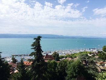 High angle view of town by sea against sky