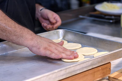 Midsection of man preparing food in kitchen