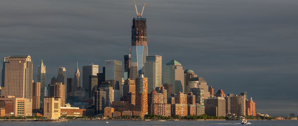 Skyscrapers in city against cloudy sky