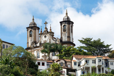 Low angle view of trees and buildings against sky