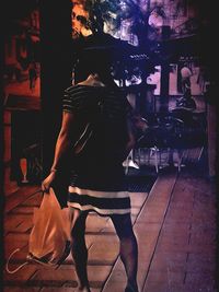 Rear view of woman walking with umbrella