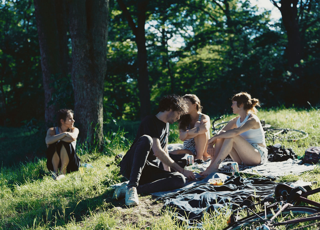 PEOPLE SITTING ON LAND