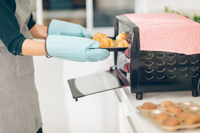 Midsection of woman preparing food in kitchen