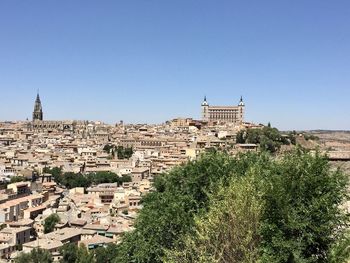 Buildings in city against clear blue sky