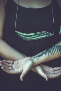 Close up woman with craft pendant and tattoo concept photo