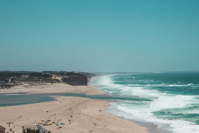 Scenic view of beach against clear blue sky